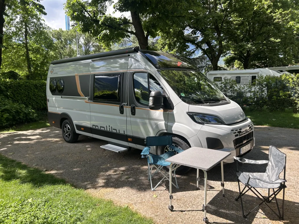 Weiterer Stellplatz mit einem Malibu Van darauf und einem Tisch- und Stuhlset