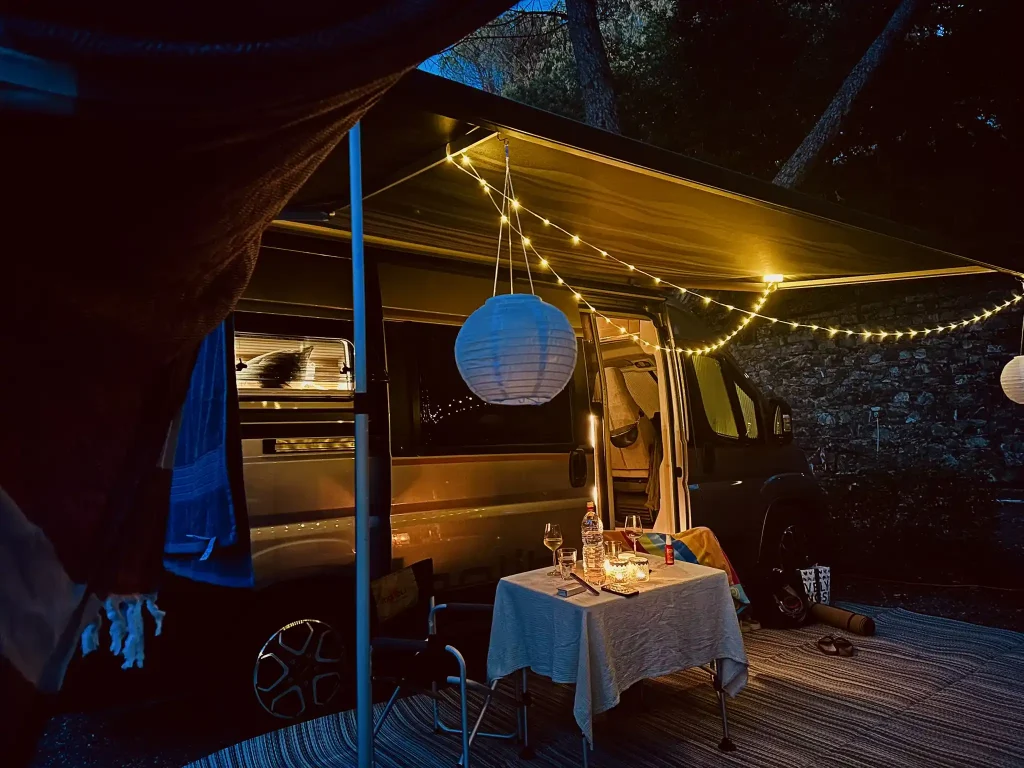 Stellplatz Malibu Van bei Nacht mit Lichterketten