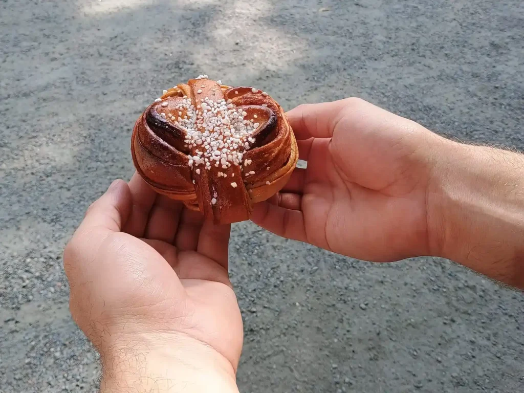 Eine Hand hält einen schwedischen Zimtknoten