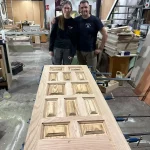 Auszubildende mit Ausbilder hinter fertiger Türe