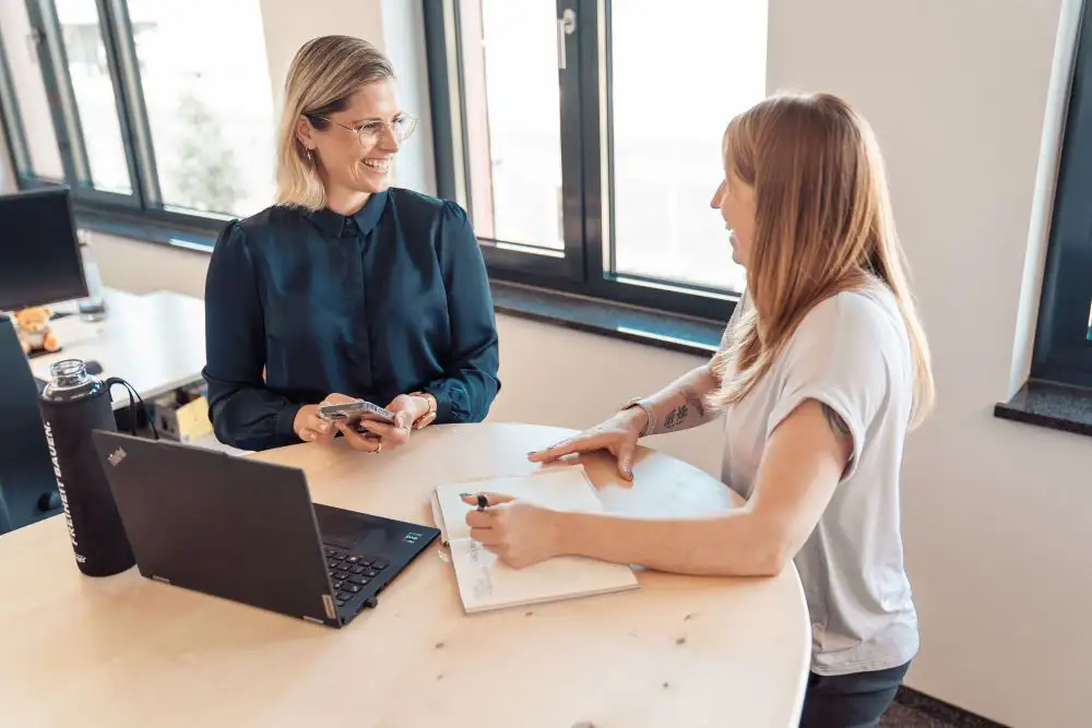 Zwei Personen sprechen am Konferenztisch