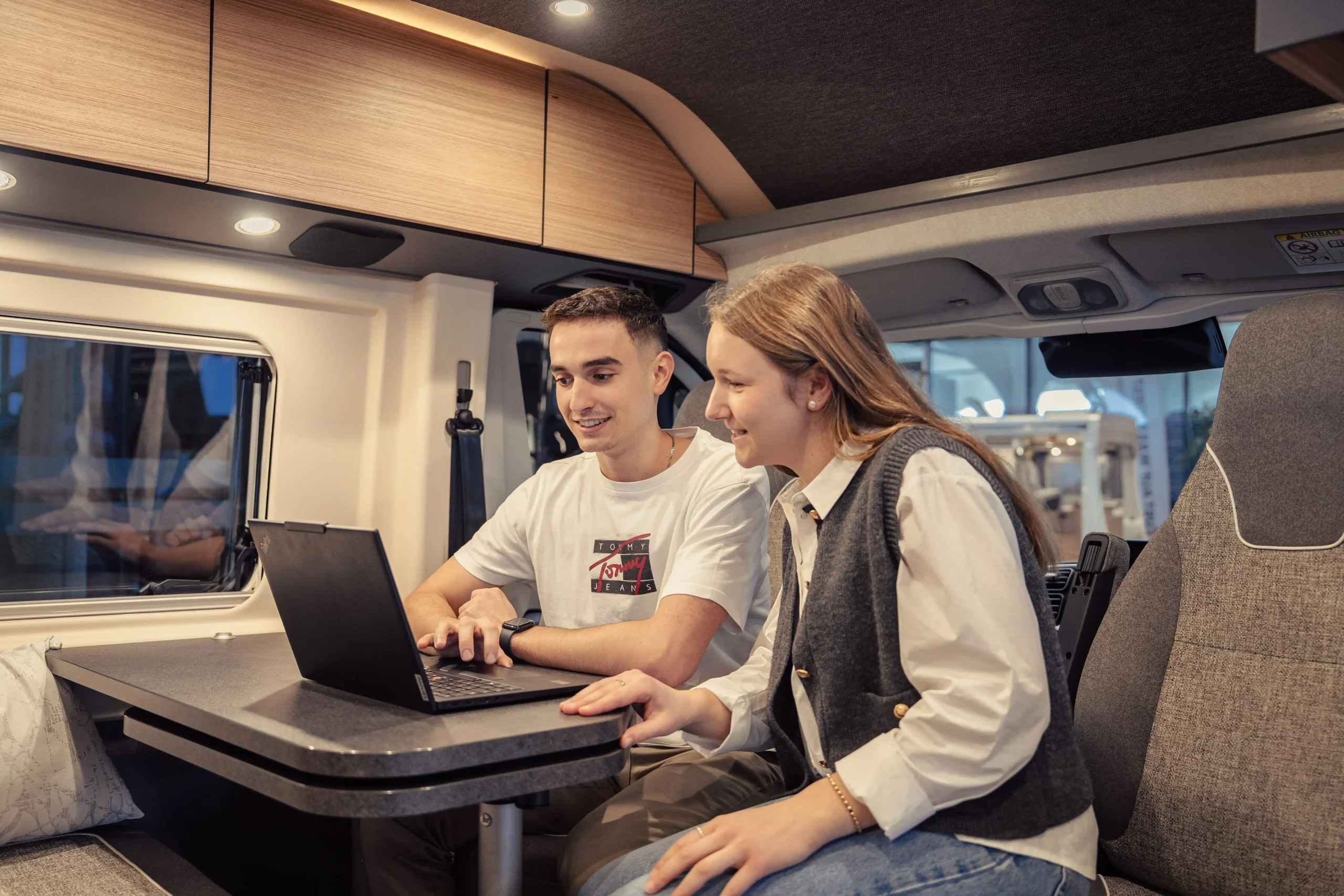 Zwei Mitarbeitende arbeiten am Laptop im Reisemobil